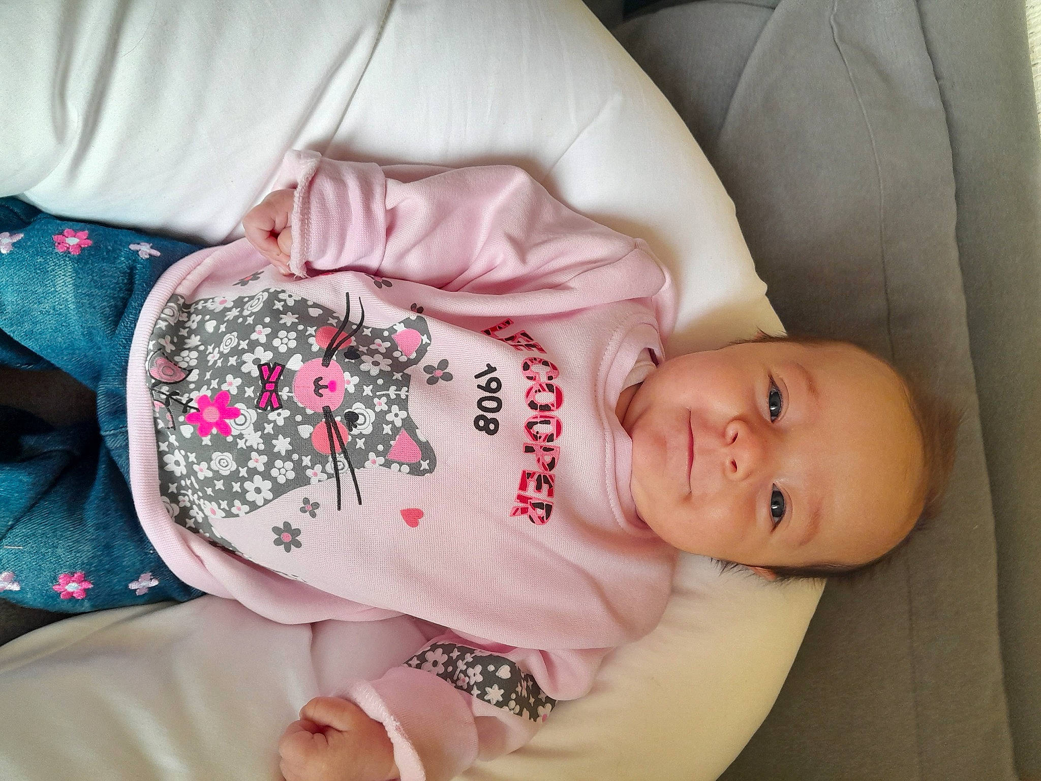 Eva participe au concours pour gagner de l'argent avec cette photo : baby, baby_products, baby_toddler_clothing, cheek, child, comfort, drinkware, eye, eyelash, finger, flesh, happy, nail, pattern, person, pink, sitting, skin, sleeve, toddler