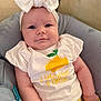 baby, bow, child, closeup, clothing, comfort, cushion, cute, face, headband, indoor, infant, lemon_graphic, person, portrait, relaxation, sitting, smiling, white_shirt, yellow_pants