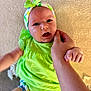 Livia participe au concours pour gagner de l'argent avec cette photo : apparel, baby, background, child, colorful, cute, expression, face, green_clothing, hand, headband, holding, indoor, infant, person, portrait, sitting, skin, texture, young