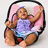 baby, infant, child, car_seat, purple_clothing, headband, happy, smiling, reaching, barefoot, indoor, seat_belt, pink, black, cute, portrait, sitting, person, studio, isolated_background