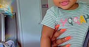 Legacy is registered to the contest to win money with this photo: baby, carpet, child, colorful, cute, door, face, hair_bows, hand, holding, indoor, laundry_basket, nails, onesie, person, rainbow_light, reflection, smile, striped_clothing, toddler
