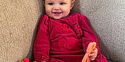 Aunaleigh joined the competition — help win amazing prizes! baby, smiling, couch, toy, colorful_toy, red_clothing, pillow, indoor, child, happy, seated, plush, fabric, person, face, hand, play, soft, home, comfort