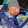 baby, sleeping, blanket, beanie, stroller, cozy, infant, child, face, peaceful, soft_texture, clothing, portrait, closeup, cute, warm, resting, comfort, young, indoors