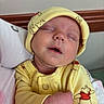baby, newborn, sleeping, yellow_clothing, hat, bear_pattern, infant, cute, peaceful, soft, portrait, child, cozy, close_up, human, resting, adorable, warm, toddler, wearing
