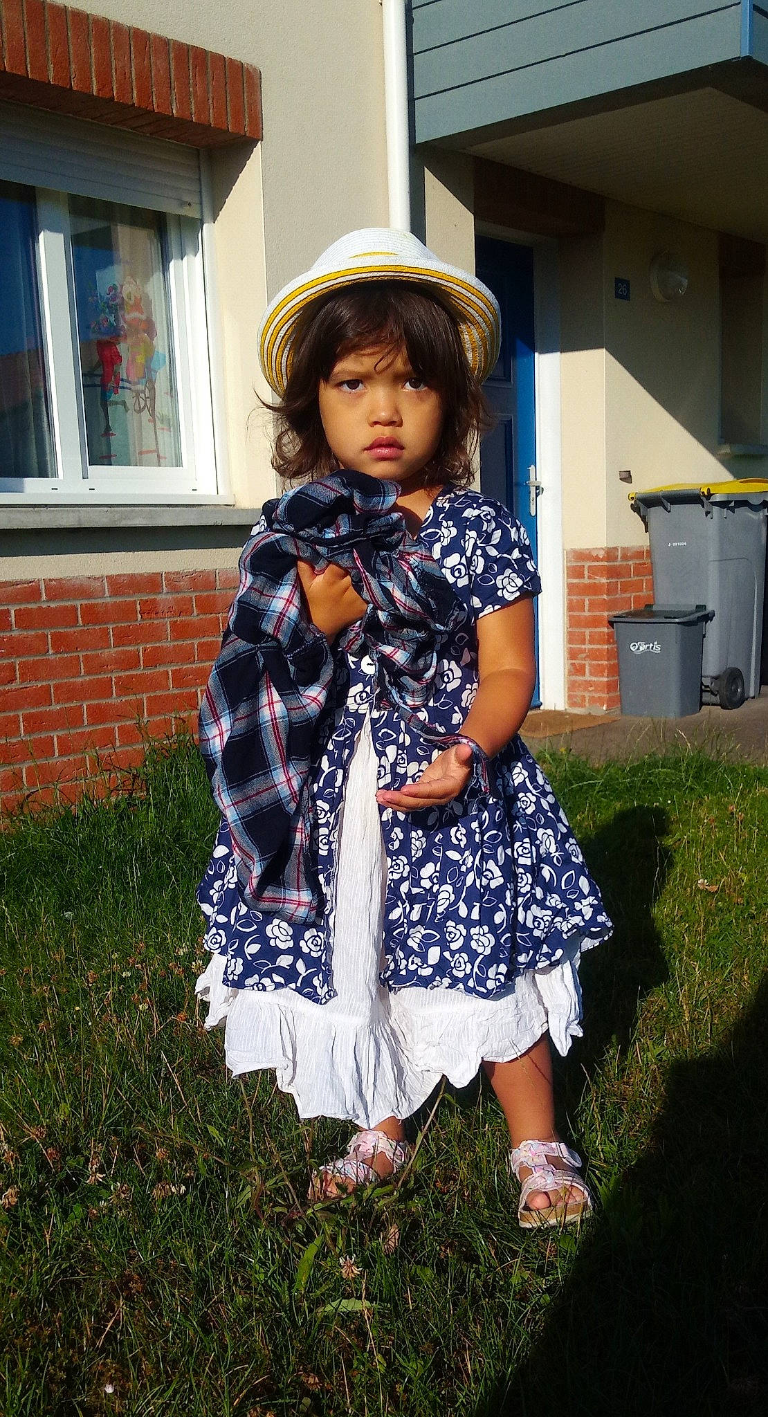 Ariana a rejoint le concours — aidez-le/la à gagner de superbes lots ! baby_toddler_clothing, bangs, day_dress, dress, embellishment, home, one_piece_garment, pattern, person, recycling_bin, sandal, sash_window, sun_hat, waste_container, waste_containment, yard