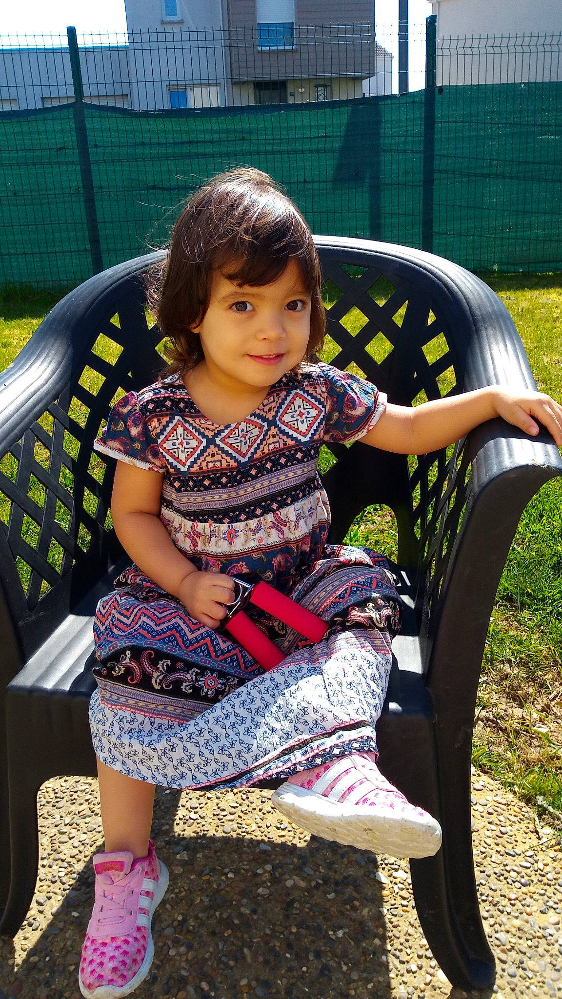 Ariana participe au concours pour gagner de l'argent avec cette photo : armrest, baby, baby_products, baby_toddler_clothing, garden, joy, lap, mouth, nose, outdoor_furniture, pattern, person, shoe, sitting, sock, toddler, yard