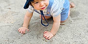 Keith joined the competition — help win amazing prizes! toddler, child, baby, hat, bucket_hat, overalls, striped_shirt, sand, outdoor, crawling, cute, curious, young_child, exploring, summer, daylight, skin, face, hands, play