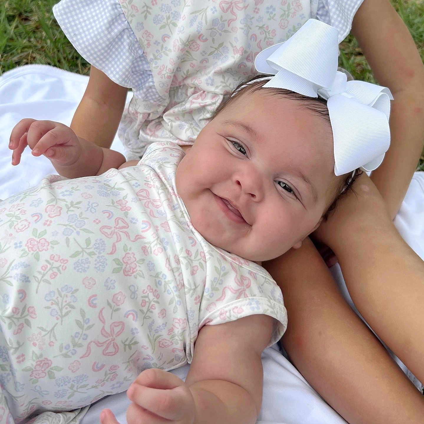 Klaire is registered to the contest to win money with this photo: arm, baby, blanket, bow, child, clothing, cute, family, grass, happy, headband, infant, nature, outdoor, person, portrait, sitting, skin, smile, toddler