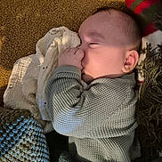 Thélio participe au concours pour gagner de l'argent avec cette photo : baby, sleeping, thumb_in_mouth, blanket, carpet, cozy, child, indoors, knitted_blanket, sweater, soft_light, peaceful, resting, portrait, cute, infant, closeup, warm, texture, comfort
