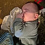 baby, sleeping, thumb_in_mouth, blanket, carpet, cozy, child, indoors, knitted_blanket, sweater, soft_light, peaceful, resting, portrait, cute, infant, closeup, warm, texture, comfort