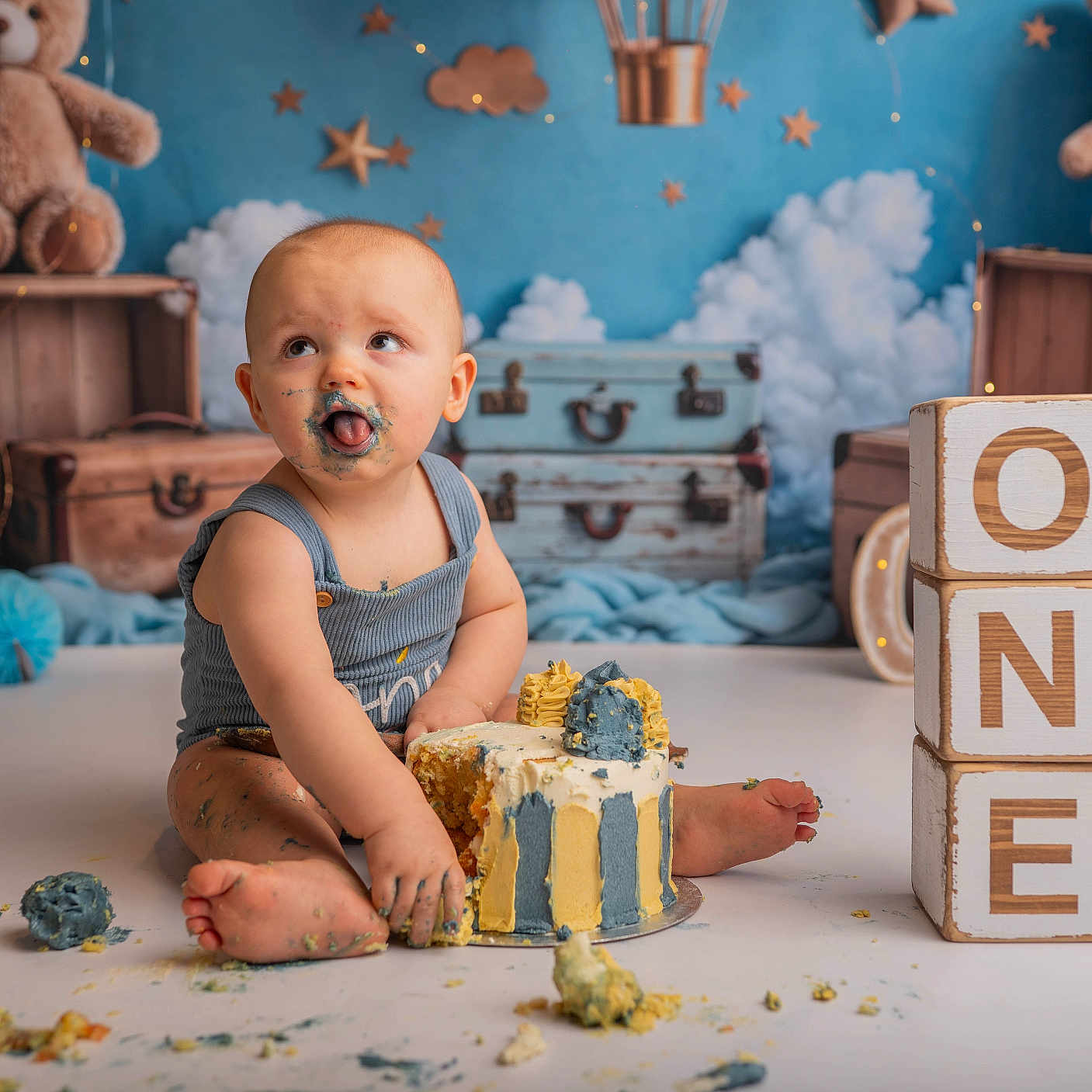 Karter Lee is registered to the contest to win money with this photo: baby, background, birthday, blocks, blue, cake, celebration, child, clouds, cute, floor, frosting, messy, one, smudged, stars, suit, teddy_bear, toy, yellow