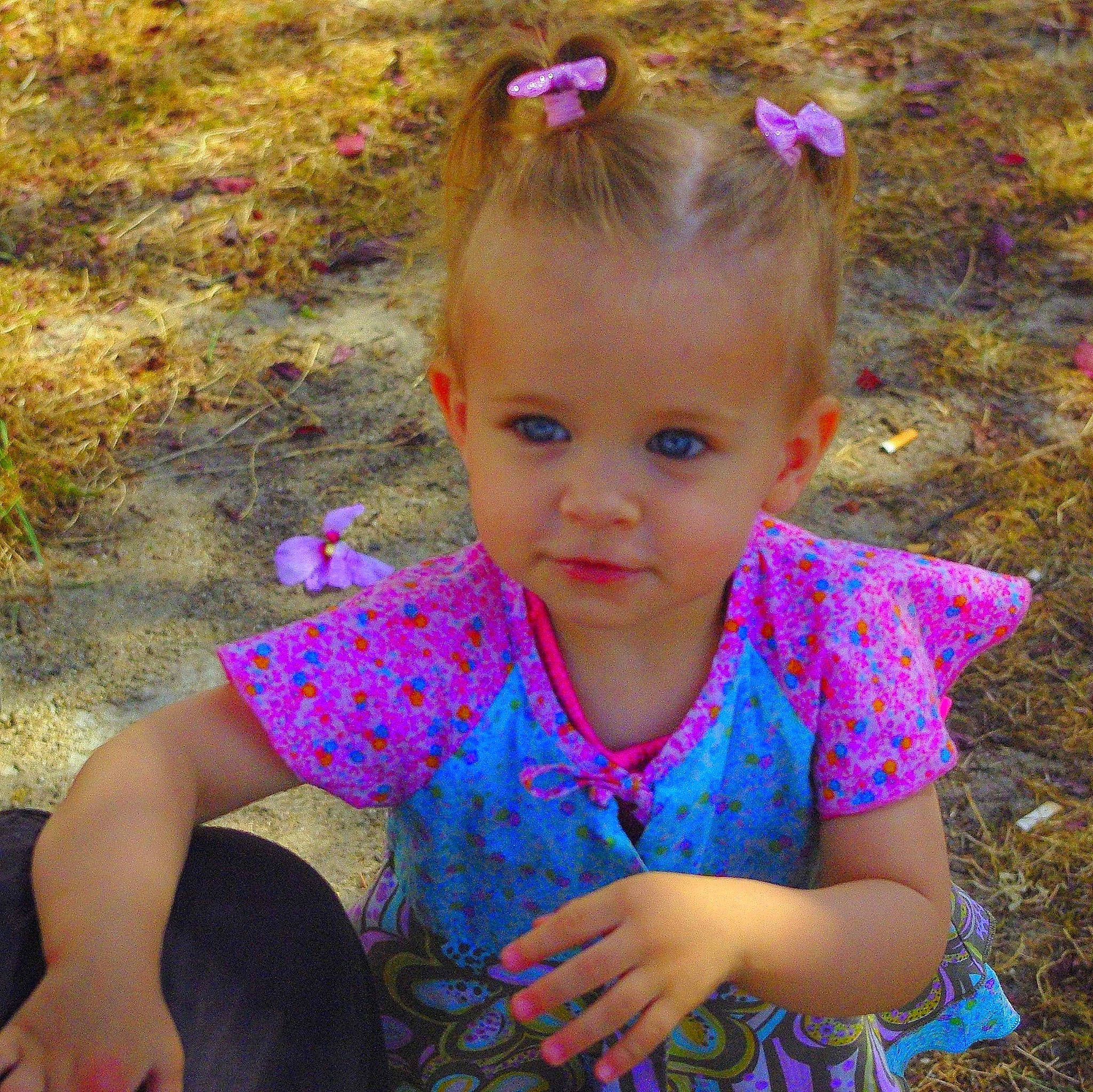Lylarose participe au concours pour gagner de l'argent avec cette photo : baby_toddler_clothing, botany, child, eye, face, flower, fun, grass, hair, happy, head, iris, leaf, magenta, people_in_nature, person, pink, plant, purple, skin
