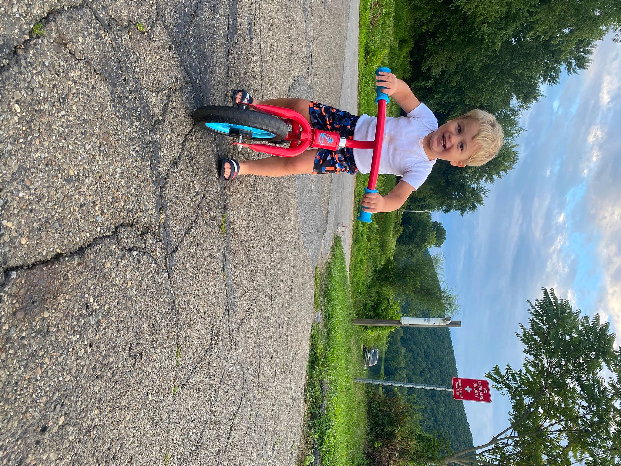 Lochlan is registered to the contest to win money with this photo: adventure, asphalt, cloud, extreme_sport, fun, joy, landscape, leisure, people_in_nature, person, plant, pole, recreation, rock_climbing_equipment, sky, slope, soil, toddler, tree, vehicle