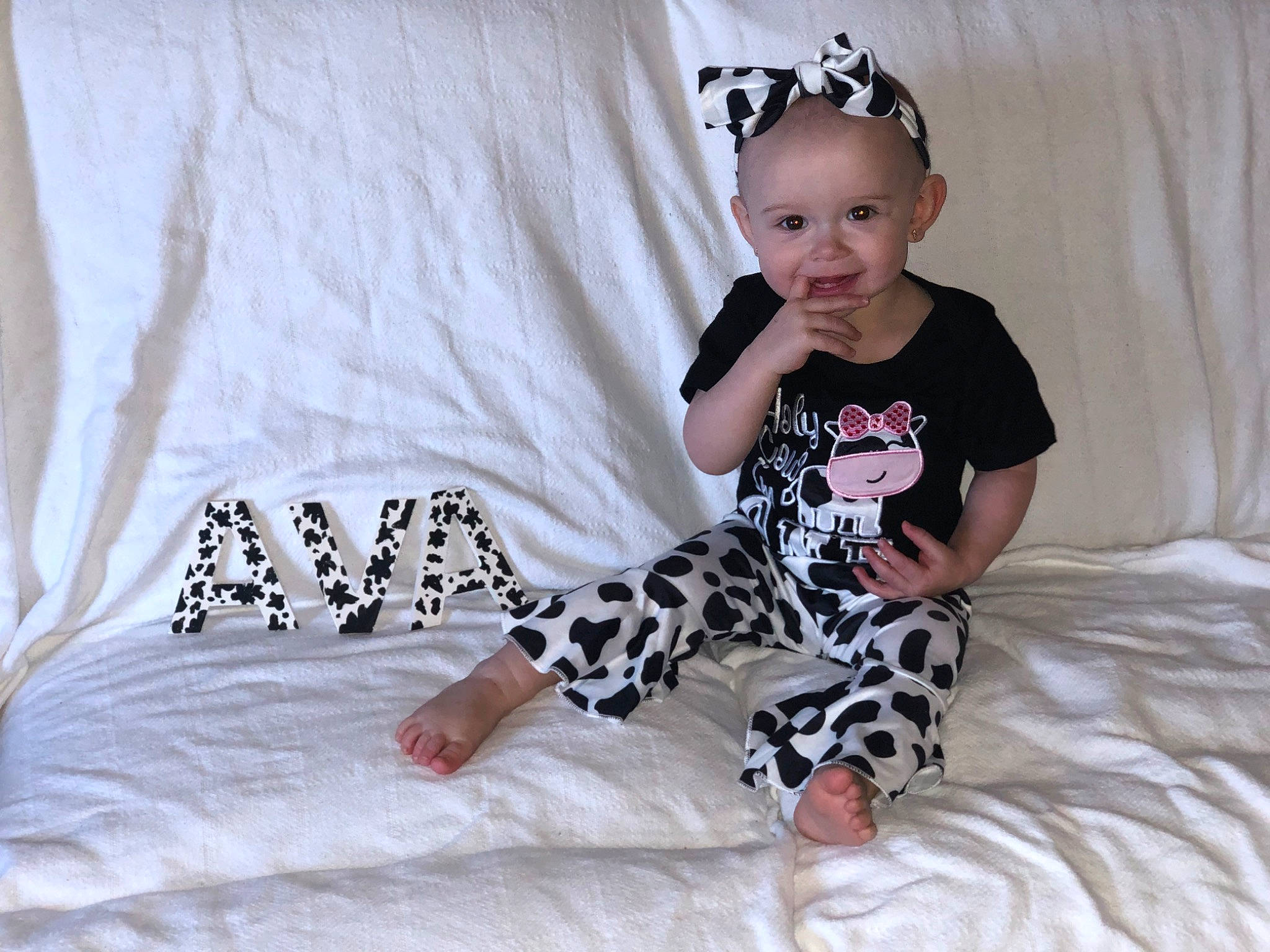 Ava Danielle joined the competition — help win amazing prizes! baby, baby_toddler_clothing, child, comfort, costume_hat, fashion_accessory, happy, head, headpiece, human_leg, jewellery, joy, knee, linens, pattern, person, sitting, sleeve, smile, t_shirt