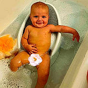 Jonathan Jr. is registered to the contest to win money with this photo: baby, bathtub, bubble_bath, child, smiling, water, bath_seat, foam, skin, relaxing, infant, sitting, clean, happy, young_child, bathroom, cute, one_person, indoors, flower_sticker