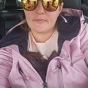 Sadie May is registered to the contest to win money with this photo: animal, car_interior, casual, closeup, dog, female, fur, headrest, indoor, jacket, person, pet, pink, portrait, reflection, seat, selfie, sunglasses, young_adult, zipper