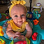 Elsie is registered to the contest to win money with this photo: activity_center, baby, big_eyes, carpet, cat, child, close_up, colorful_toys, drool, fan, furniture, headband, infant, living_room, pet, play_center, seat, smile, toy, yellow_headband