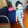 Daysean joined the competition — help win amazing prizes! child, toddler, portrait, standing, smiling, hat, baseball_cap, curly_hair, indoor, living_room, sofa, chair, television, flowers, wood_floor, clothing, t_shirt, race_cars, pants, shoes