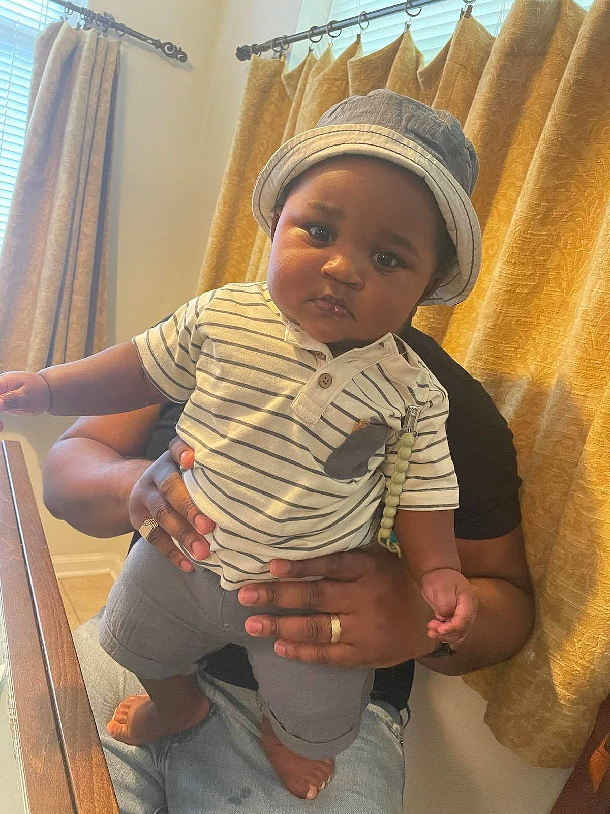Louis is registered to the contest to win money with this photo: abdomen, baby, baby_toddler_clothing, cheek, child, comfort, curtain, elbow, fun, happy, headwear, human_leg, knee, person, sitting, skin, sleeve, standing, thigh, thumb