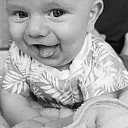 Emile a rejoint le concours — aidez-le/la à gagner de superbes lots ! baby, infant, tongue_out, smiling, black_and_white, blanket, patterned_clothing, cute, face, head, closeup, happy, child, person, indoors, soft_texture, young, playful, eyes, skin