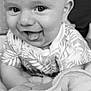 baby, infant, tongue_out, smiling, black_and_white, blanket, patterned_clothing, cute, face, head, closeup, happy, child, person, indoors, soft_texture, young, playful, eyes, skin