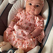 Katalia Harris joined the competition — help win amazing prizes! baby, infant, pink_dress, headband, plush_toy, baby_seat, cushion, bracelet, flower_pattern, soft_toy, indoors, cute, child, portrait, baby_clothes, comfortable, sitting, adorable, young_child, baby_accessories