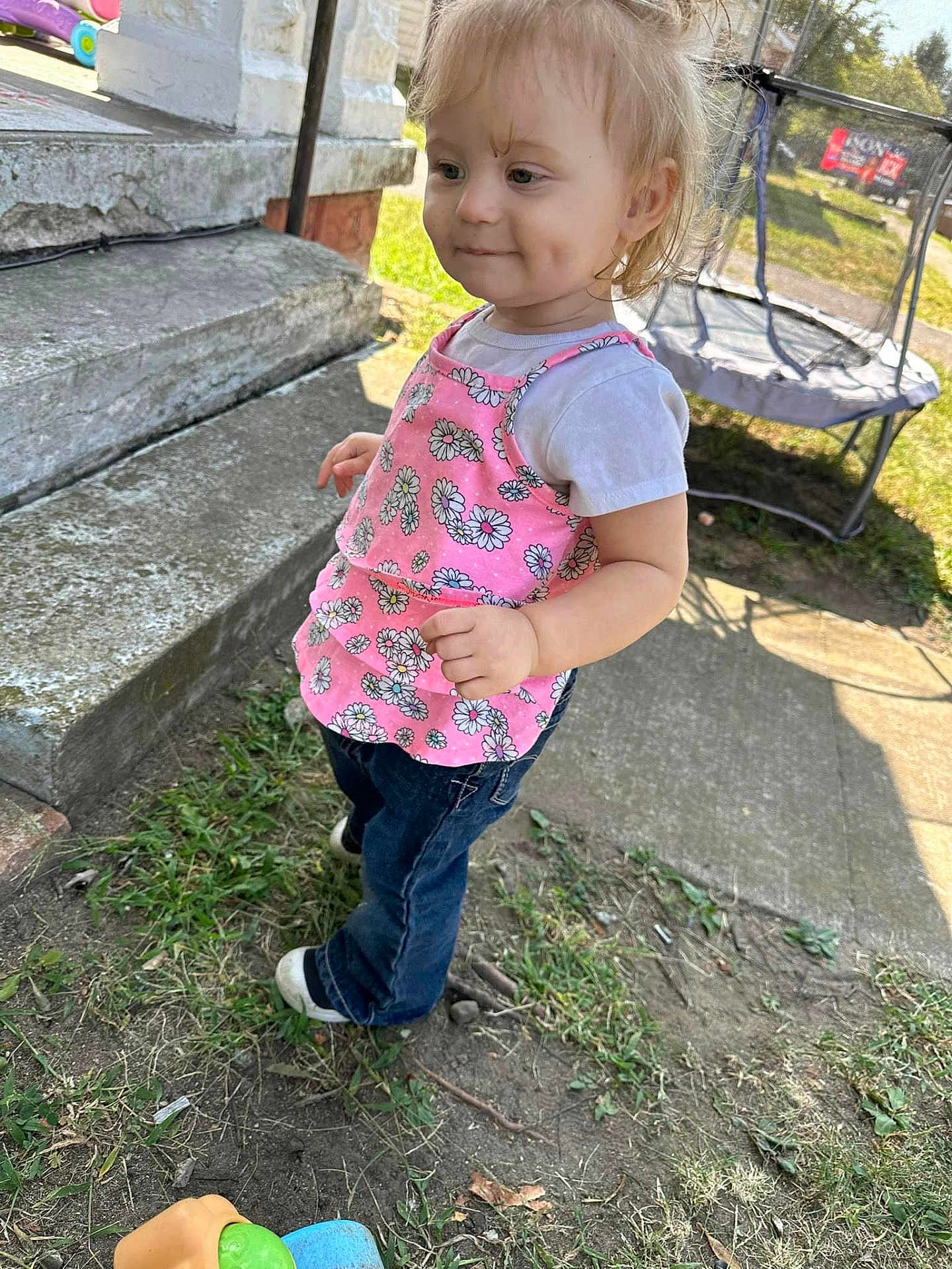 Mia Govero is registered to the contest to win money with this photo: toddler, child, outdoor, grass, jeans, pink_top, smile, dimples, concrete_steps, trampoline, sunlight, playing, young_child, casual_clothing, daytime, person, footwear, side_view, nature, happy