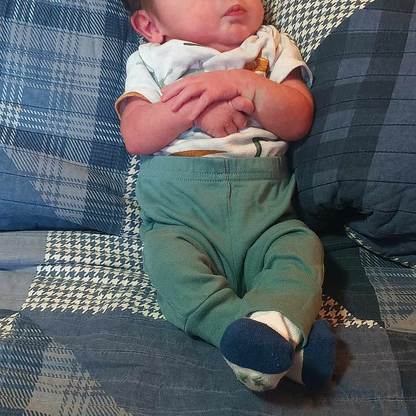 Noah is registered to the contest to win money with this photo: baby, bed, child, clothing, cozy, cute, fabric, furniture, headboard, indoor, infant, pattern, person, plaid, portrait, quilt, resting, socks, wood, young