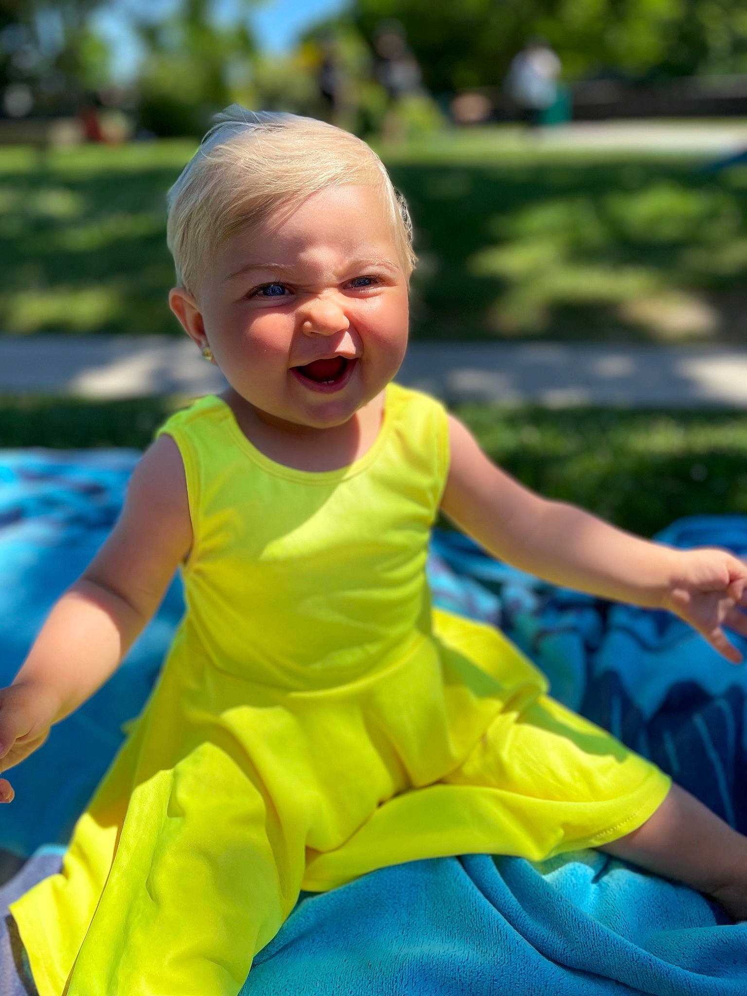 Mia a rejoint le concours — aidez-le/la à gagner de superbes lots ! baby, baby_toddler_clothing, child, electric_blue, face, facial_expression, fun, grass, happy, leisure, people_in_nature, person, plant, recreation, sitting, skin, sleeve, smile, t_shirt, toddler