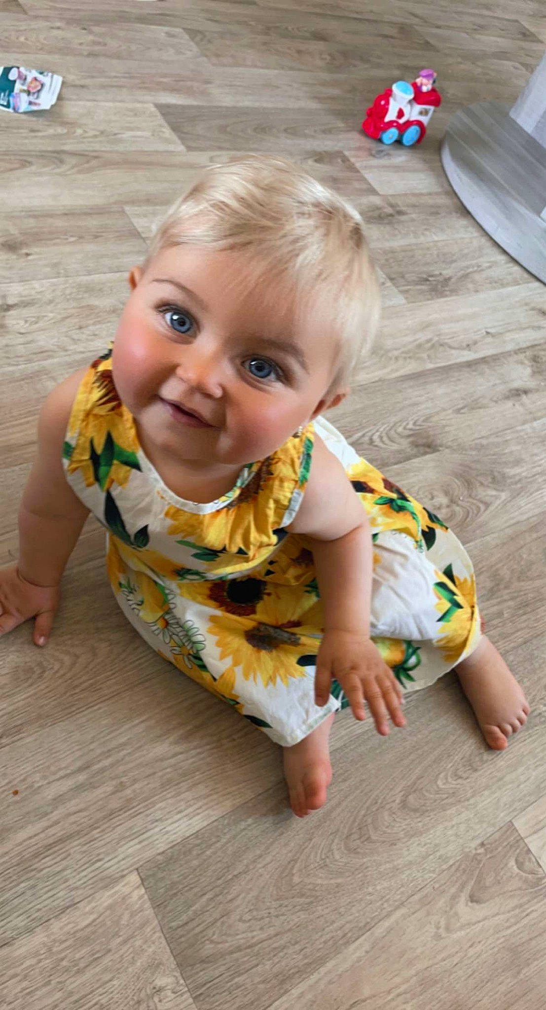 Mia participe au concours pour gagner de l'argent avec cette photo : baby, baby_toddler_clothing, blue, cheek, child, chin, crawling, dress, floor, flooring, fun, hair, happy, hardwood, leisure, person, skin, sleeve, smile, toddler