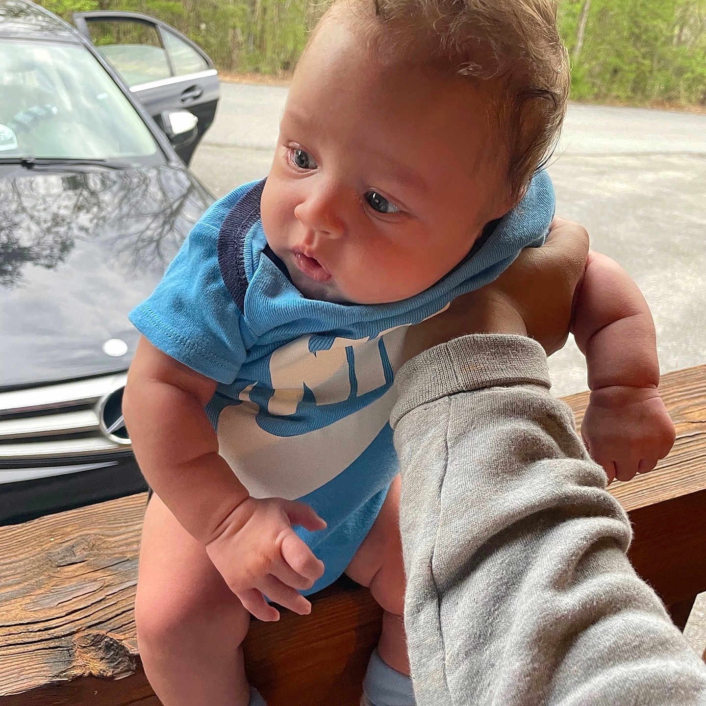 Messiah is registered to the contest to win money with this photo: baby, car, clothing, face, footwear, head, machine, outdoors, pants, person, photography, plant, portrait, shoe, sitting, transportation, tree, vegetation, vehicle, wheel