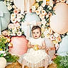 child, toddler, dress, headband, flower, easter_egg, bow, mat, barefoot, portrait, indoor, decor, pastel_colors, celebration, spring, cute, innocence, flower_arrangement, sitting, person
