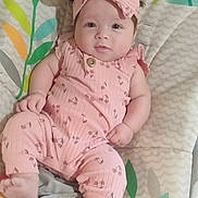 Novian is registered to the contest to win money with this photo: baby, child, infant, pink_clothing, headband, bow, lying_down, playmat, animal_pattern, leaf_pattern, cute, portrait, face, feet, hand, soft_toys, indoor, childcare, smiling, comfortable