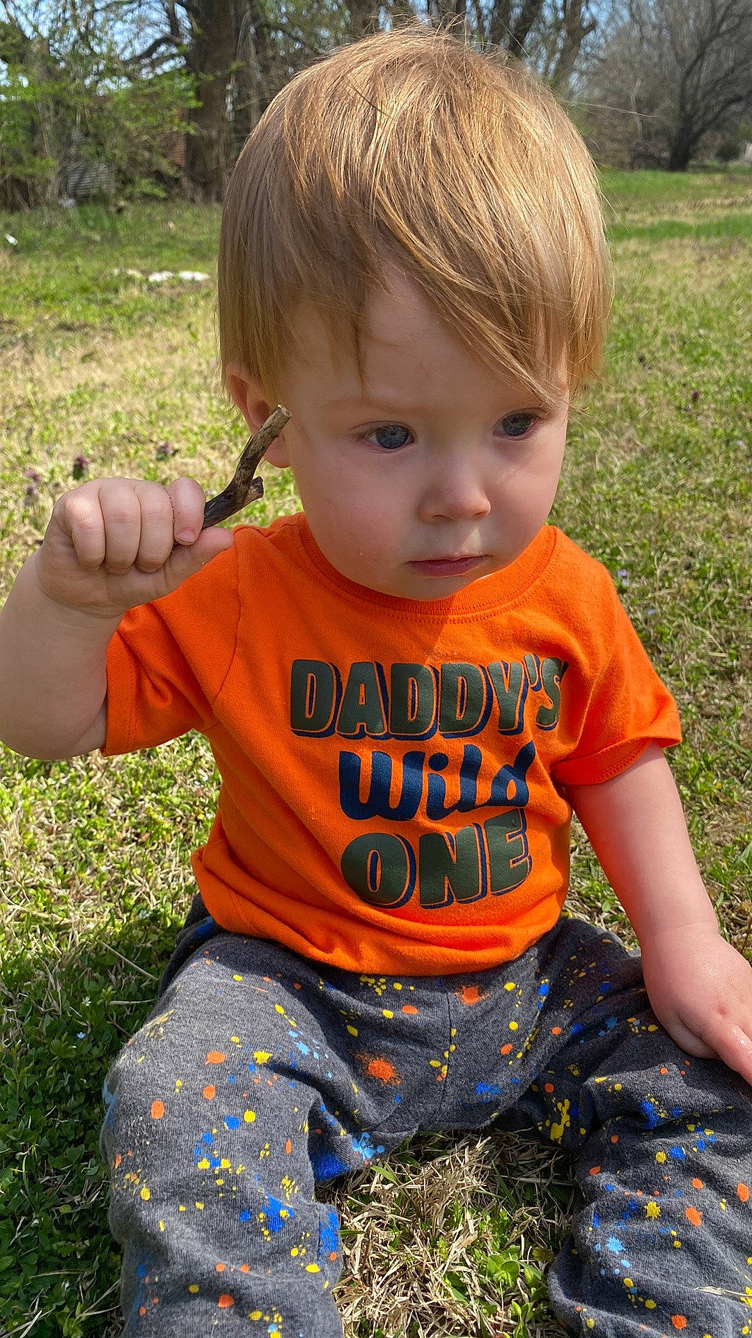 Azrael is registered to the contest to win money with this photo: baby_toddler_clothing, cool, facial_expression, finger, fun, grass, hair, hairstyle, hand, happy, head, human_body, leaf, nose, orange, people_in_nature, person, plant, skin, sleeve