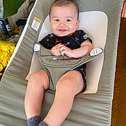 Elijah joined the competition — help win amazing prizes! baby, smiling, infant, baby_bouncer, clothing, socks, hands, face, happy, indoor, plant, furniture, wood_floor, seat, child, cute, portrait, relaxed, casual, home