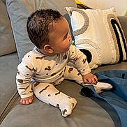 Ismaïl participe au concours pour gagner de l'argent avec cette photo : baby, child, pajamas, sitting, pacifier, couch, pillows, curly_hair, indoor, cozy, clothing, footed_pajamas, person, furniture, soft_toys, home, cute, infant, relaxed, casual