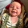 baby, smiling, infant, close_up, cute, face, child, outdoor, apparel, clothing, animal_print, green, striped_shirt, happy, portrait, young, skin, head, eyes, blanket