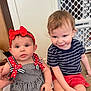 Lisa is registered to the contest to win money with this photo: baby, candid, carpet, child, curly_hair, cute, dress, face, floor, hand, headband, indoor, person, playful, red_bow, shorts, sitting, smiling, striped_shirt, toddler