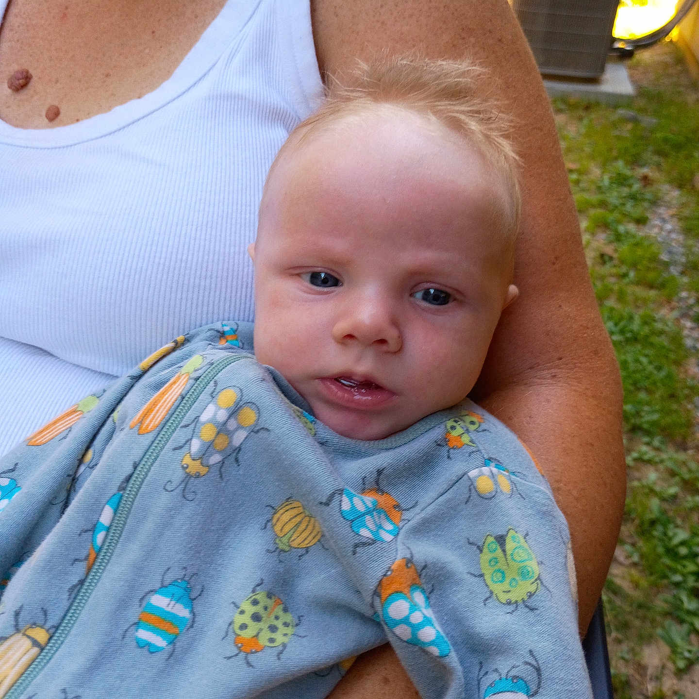 Hunter joined the competition — help win amazing prizes! baby, infant, child, portrait, face, eyes, blond_hair, sitting, being_held, adult, arms, onesie, bug_pattern, outdoor, grass, garden, speaker, daylight, close_up, family