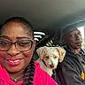 Snowball joined the competition — help win amazing prizes! woman, man, dog, people, car, interior, selfie, portrait, smiling, glasses, braid, pink_clothing, hoodie, driver, passenger, pet, seated, indoors, vehicle, daylight