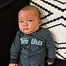 Adam is registered to the contest to win money with this photo: baby, infant, child, portrait, sitting, couch, sofa, pillow, cushion, striped_clothing, onesie, pajamas, black_and_white, indoors, home, face, eyes, serious_expression, photography, furniture