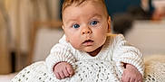 Alexis a rejoint le concours — aidez-le/la à gagner de superbes lots ! baby, infant, blue_eyes, sweater, knitted_blanket, curious, face, hands, closeup, portrait, indoors, warm, soft_light, child, cute, young, person, skin, expression, home