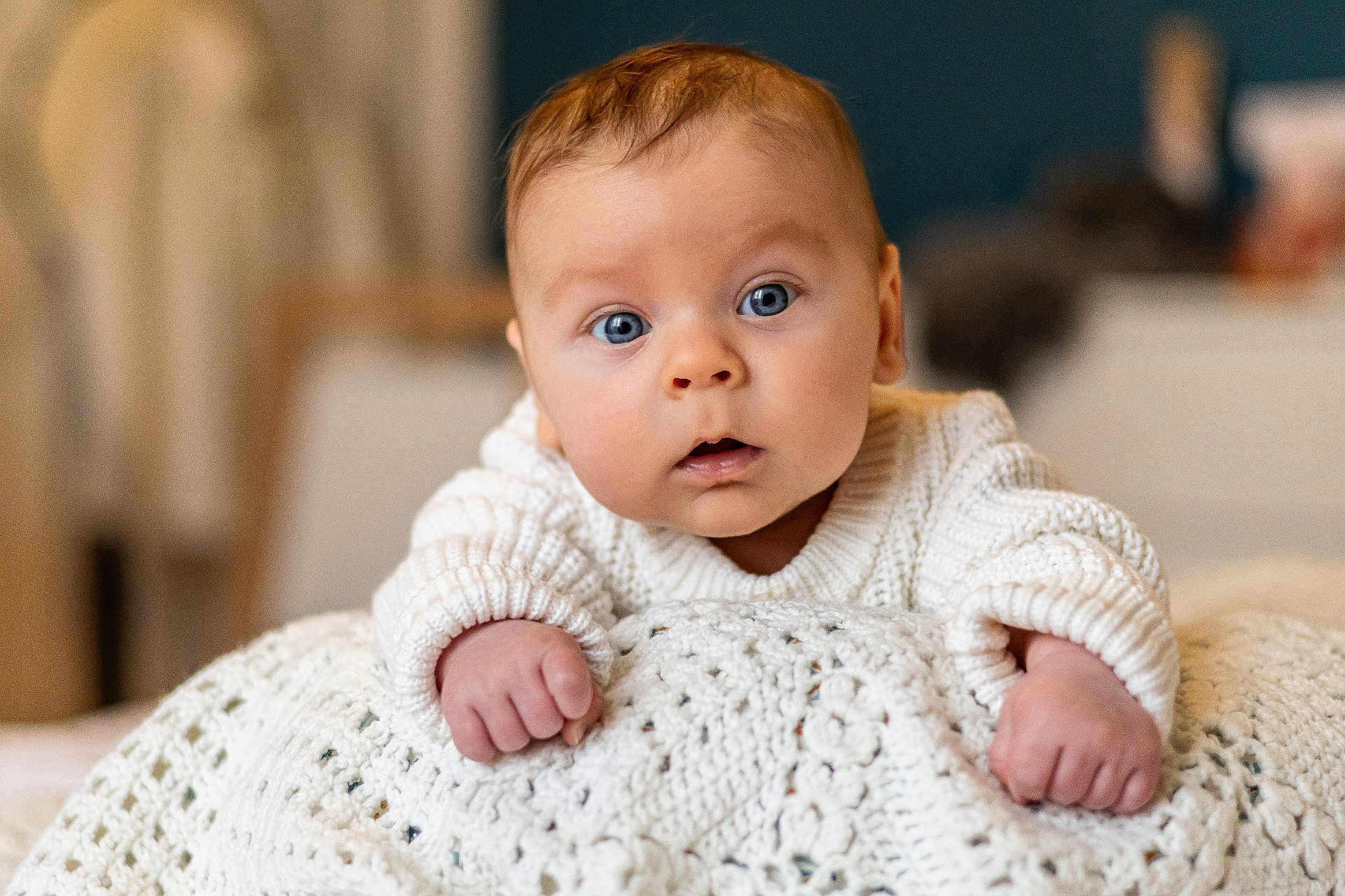 Alexis a rejoint le concours — aidez-le/la à gagner de superbes lots ! baby, infant, blue_eyes, sweater, knitted_blanket, curious, face, hands, closeup, portrait, indoors, warm, soft_light, child, cute, young, person, skin, expression, home