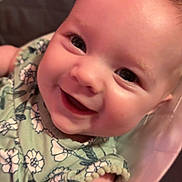 Eliana is registered to the contest to win money with this photo: baby, infant, child, smiling, happy, portrait, close_up, face, eyes, floral_clothing, green_outfit, seated, baby_seat, pink, indoor, cozy, photography, cute, joyful, head