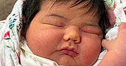 Samira is registered to the contest to win money with this photo: baby, newborn, sleeping, face, hair, bow, blanket, floral, wrapped, cute, skin, infant, peaceful, pout, chubby, closeup, soft, hand, resting, indoors