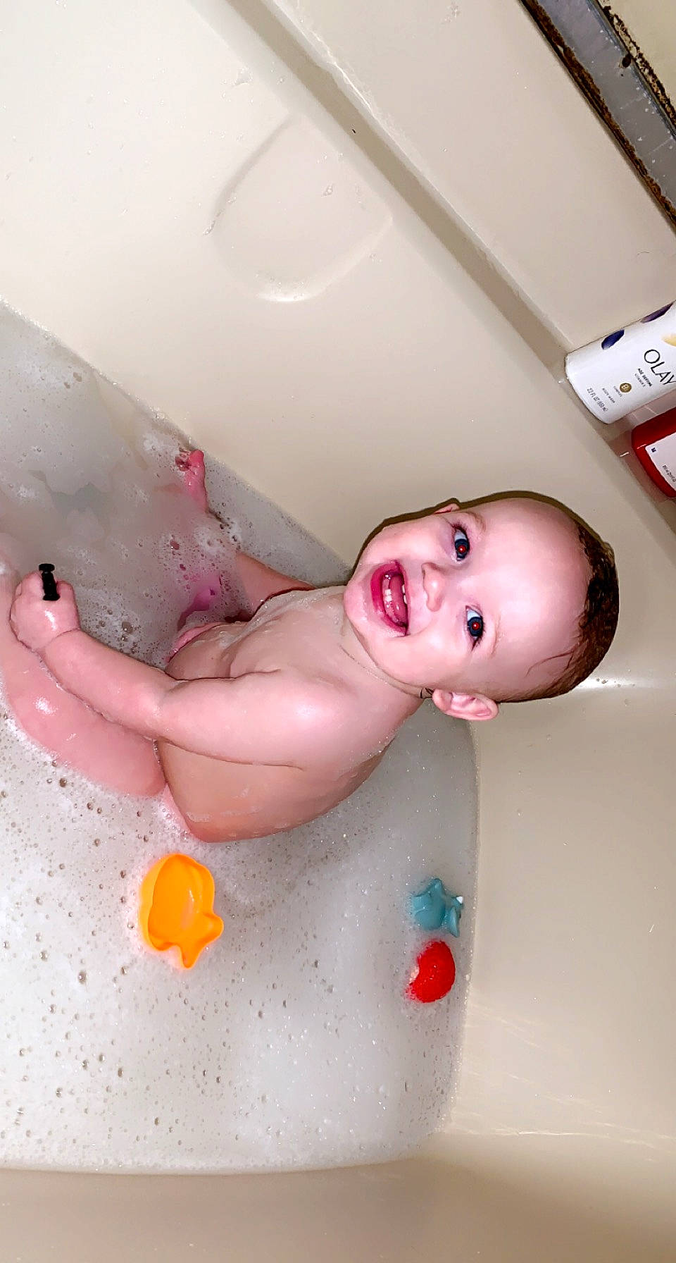Kyle is registered to the contest to win money with this photo: arm, baby, bathing, bathtub, cheek, chest, eye, face, finger, hand, head, human_body, joy, leg, mammal, mouth, person, pink, product, skin