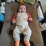 baby, infant, smiling, changing_table, overalls, striped_shirt, orange_socks, blanket, towel, baby_wipes, diaper_changer, nursery, happy, clothing, face, hands, gaze, overhead_view, cozy, indoor