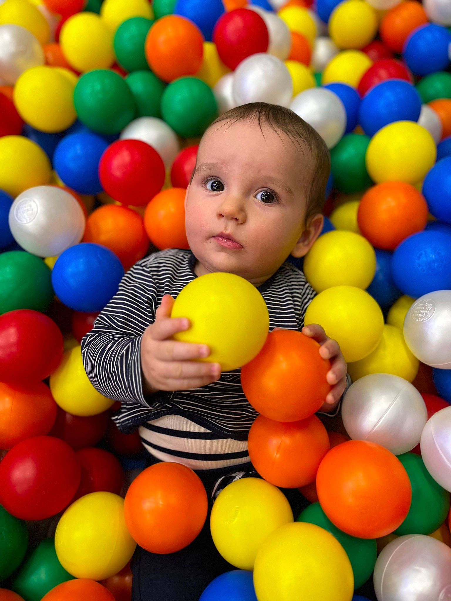 Juan participe au concours pour gagner de l'argent avec cette photo : baby_playing_with_toys, ball, ball_pit, child, event, facial_expression, fun, happy, leisure, natural_foods, people, person, play, playground, playing_sports, product, recreation, sports_toy, sweetness, toddler