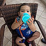 baby, blue, cartoon_character, child, cute, drink, hand, life_jacket, orange, outdoor, patio, sandals, sippy_cup, sitting, summer, tile_floor, toddler, water_safety, wicker_chair, young_child