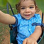 Yeshua is registered to the contest to win money with this photo: blue_shirt, child, closeup, curly_hair, face, fun, grass, hand, happy, joy, nature, outdoor, park, person, play, rings, smiling, summer, swing, toddler